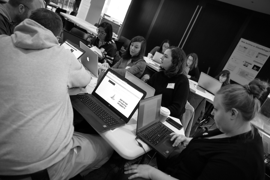 a group of people in a library around laptops